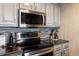 Stainless steel appliances and gray cabinetry in kitchen at 12762 Ironstone Way # 302, Parker, CO 80134