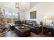 Comfortable living room with a brown leather sectional sofa, decorative pillows, and a coffee table trunk at 12762 Ironstone Way # 302, Parker, CO 80134