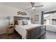 Relaxing main bedroom featuring a ceiling fan, bedside lamps, and a window with views of the neighborhood at 12762 Ironstone Way # 302, Parker, CO 80134