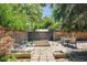 The backyard features raised garden beds, a dining area, and a patio with seating at 1360 S Hudson St, Denver, CO 80222