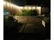 Cozy backyard illuminated at night with garden beds and stone tile ground covering at 1360 S Hudson St, Denver, CO 80222