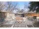 Spacious backyard with a paved area, garden beds, outdoor dining set, and a wooden privacy fence at 1360 S Hudson St, Denver, CO 80222