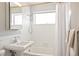 Classic bathroom features a pedestal sink, bathtub with shower, and a large window at 1360 S Hudson St, Denver, CO 80222