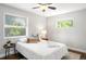 Bright bedroom features a ceiling fan, hardwood floors, and natural light from two windows at 1360 S Hudson St, Denver, CO 80222
