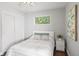 Bedroom with dark wood floors, light walls, fan, and view of the closet through large window at 1360 S Hudson St, Denver, CO 80222