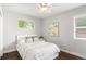 Cozy bedroom with light walls, dark wood floors, fan, and natural light from two windows at 1360 S Hudson St, Denver, CO 80222