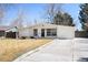Well-maintained single-story house with a white exterior, attached garage, and long driveway at 1360 S Hudson St, Denver, CO 80222