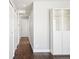 Hallway with hardwood floors, white walls, multiple closets, and a storage cabinet at 1360 S Hudson St, Denver, CO 80222