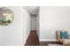 Hallway with dark wood floors, white walls, and a view of interior doors with decor at 1360 S Hudson St, Denver, CO 80222
