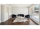 Bright living room with dark wood floors, black sofa set, and a stylish faux cowhide rug at 1360 S Hudson St, Denver, CO 80222