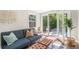 Sun room features a comfortable blue sofa, natural light, and access to the backyard patio at 1360 S Hudson St, Denver, CO 80222
