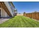 Well-manicured backyard with a freshly cut lawn and wooden fence, ideal for outdoor activities at 5221 E 143Rd Dr, Thornton, CO 80602