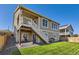 Manicured backyard with wooden stairs, a well-maintained lawn, and an outdoor living space at 5221 E 143Rd Dr, Thornton, CO 80602