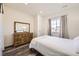 Cozy bedroom with wood laminate flooring, dresser, a window, and neutral walls at 5221 E 143Rd Dr, Thornton, CO 80602