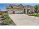 Inviting home featuring a three-car garage, manicured lawn, and beautiful landscaping at 5221 E 143Rd Dr, Thornton, CO 80602
