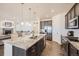 Open kitchen featuring granite countertops, stainless steel appliances, a large island, and hardwood flooring at 5221 E 143Rd Dr, Thornton, CO 80602