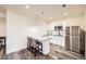 Bright kitchen featuring white cabinets, a granite island with seating, and stainless steel appliances at 5221 E 143Rd Dr, Thornton, CO 80602