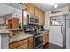 This kitchen features stainless steel appliances, granite countertops, and wooden cabinets at 10150 E Virginia Ave # 11-202, Denver, CO 80247