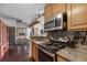 Kitchen and dining area featuring wood cabinets, granite countertops, and stainless appliances at 10150 E Virginia Ave # 11-202, Denver, CO 80247