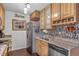 Compact kitchen with stainless steel appliances, granite countertops, and wood cabinetry at 10150 E Virginia Ave # 11-202, Denver, CO 80247