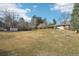 Expansive backyard with mature trees, a lush lawn, and a peek at the house, creating a serene outdoor retreat at 7076 S Verbena Cir, Centennial, CO 80112