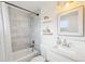 Well-lit bathroom features tiled shower and tub, sleek white vanity, and decorative shelving at 7076 S Verbena Cir, Centennial, CO 80112