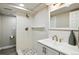 Modern bathroom featuring textured white tile, mosaic floor, and updated fixtures at 9664 W Grand Ave, Littleton, CO 80123