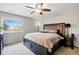 Comfortable bedroom featuring a large window, ceiling fan, carpeted floor, and stylish furnishings at 9664 W Grand Ave, Littleton, CO 80123