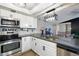 Modern kitchen featuring stainless steel appliances, granite countertops, and white cabinetry at 9664 W Grand Ave, Littleton, CO 80123