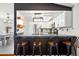 Modern kitchen with stainless steel appliances, a breakfast bar, and a view of the dining area at 9664 W Grand Ave, Littleton, CO 80123