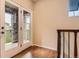 Bright room featuring hardwood floors and double doors that lead to a cozy balcony with stone accents at 9470 Loggia St # D, Highlands Ranch, CO 80126