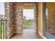 Charming balcony with stone columns and iron railings, overlooking a serene street view at 9470 Loggia St # D, Highlands Ranch, CO 80126