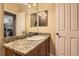 Cozy bathroom featuring a granite countertop, modern sink, and well-lit mirror at 9470 Loggia St # D, Highlands Ranch, CO 80126