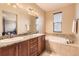 A spacious bathroom featuring double sinks, a soaking tub, and granite countertops at 9470 Loggia St # D, Highlands Ranch, CO 80126