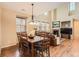 Open-concept dining and living area with wood floors, neutral walls, and comfortable seating near the fireplace at 9470 Loggia St # D, Highlands Ranch, CO 80126
