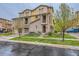 Attractive multi-story townhouse featuring stone accents, private balconies, and a well-maintained lawn at 9470 Loggia St # D, Highlands Ranch, CO 80126