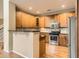 Charming kitchen with wood cabinets, granite countertops, and stainless steel appliances at 9470 Loggia St # D, Highlands Ranch, CO 80126