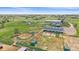 Aerial view of horse property featuring a large barn, riding arena, paddocks, and scenic green surroundings at 9255 N Delbert Rd, Parker, CO 80138