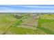 An aerial view showcasing expansive acreage with fenced pastures, horse shelters, outbuildings, and a large barn at 9255 N Delbert Rd, Parker, CO 80138