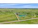 Expansive aerial view of the property featuring green pastures, multiple buildings, and stunning mountain views in the distance at 9255 N Delbert Rd, Parker, CO 80138