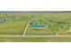 Expansive aerial view of the property featuring green pastures, multiple buildings, and stunning mountain views in the distance at 9255 N Delbert Rd, Parker, CO 80138