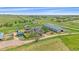 Beautiful aerial view of horse property with a large barn, several outbuildings and surrounding green pasture at 9255 N Delbert Rd, Parker, CO 80138