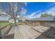 Spacious backyard deck with a tree providing plenty of shade and blue skies above at 9255 N Delbert Rd, Parker, CO 80138