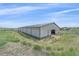 Equestrian barn with green trim and metal siding located on grassy field at 9255 N Delbert Rd, Parker, CO 80138