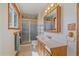 Bright bathroom featuring a wood vanity, a large mirror, and a stand-up shower with a glass door at 9255 N Delbert Rd, Parker, CO 80138