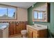 A green downstairs bathroom featuring wooden trim, a utility sink, and wood-look flooring at 9255 N Delbert Rd, Parker, CO 80138