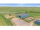 Aerial view of the horse barn with adjacent paddocks and pasture. A beautiful home for your horses at 9255 N Delbert Rd, Parker, CO 80138