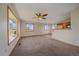 Open floor plan living room featuring large windows, neutral carpet, and a ceiling fan at 9255 N Delbert Rd, Parker, CO 80138