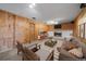 Cozy living room with a brick fireplace, wood walls, carpet, and comfortable seating for relaxing evenings at 9255 N Delbert Rd, Parker, CO 80138