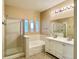Bright bathroom with double vanity, tub, and glass-enclosed shower at 6725 S Winnipeg Cir # 106, Aurora, CO 80016